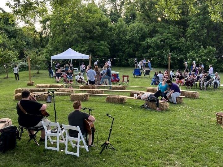 Event attendees listening to two guitarists outside