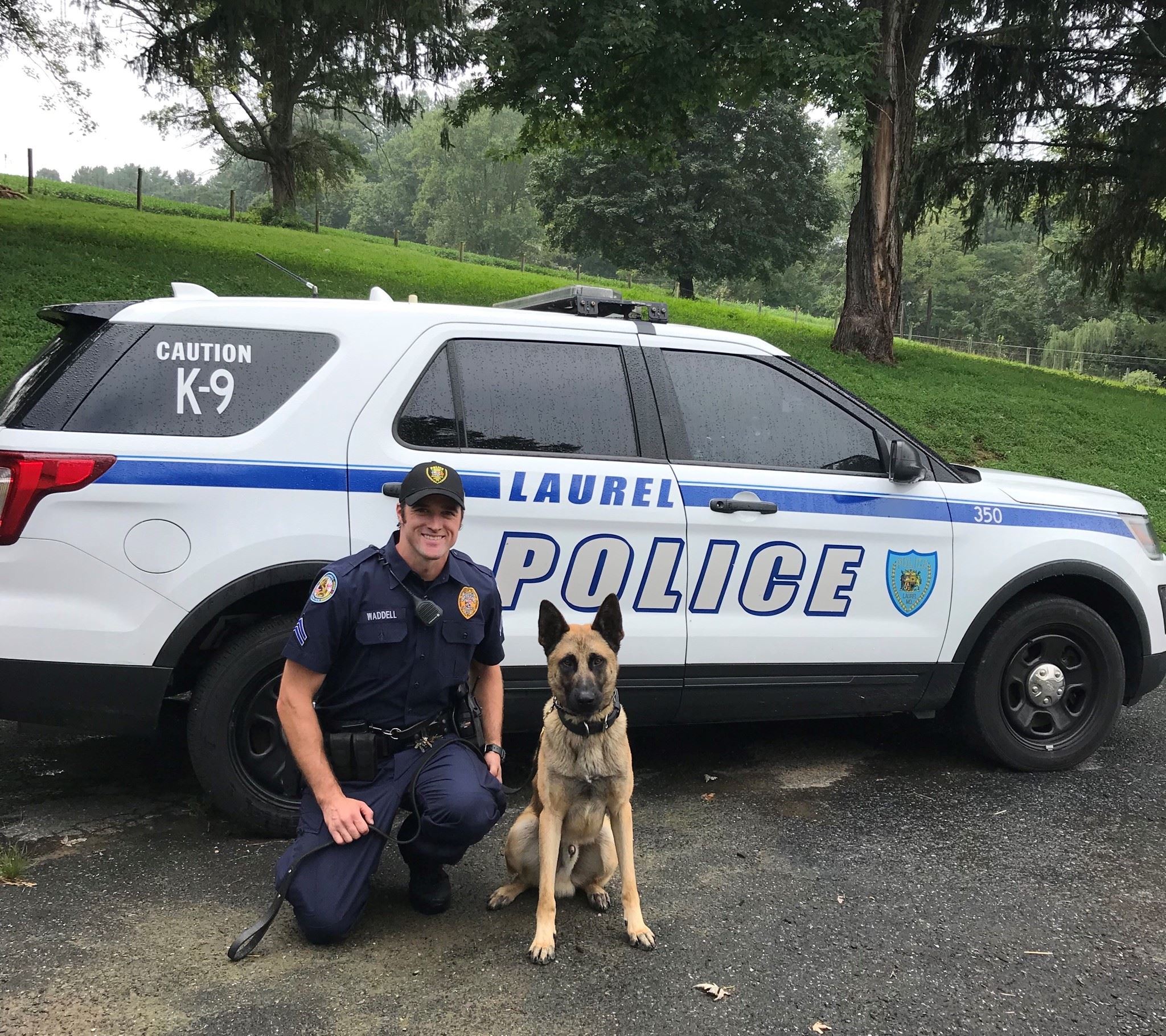 A Police Officer and a Dog Next to a Dog